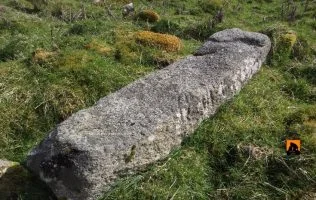 Kilgarvan Ogham stone lying flat in Kilgarvan graveyard, Co. Mayo